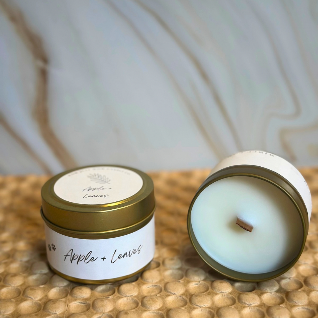 Unlit soy candle tin with Apple + Leaves label, gold lid and exposed wick
