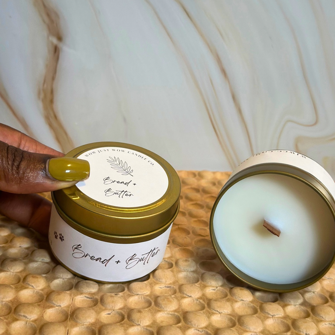 Open gold soy candle with white wax and wick, lid removed with 'Bread + Butter' label