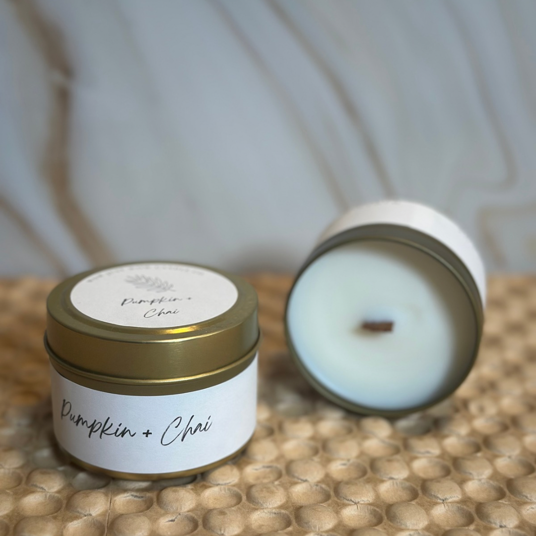 Gold-lidded Pumpkin + Chai soy candle tin with unlit wick in blue jar.