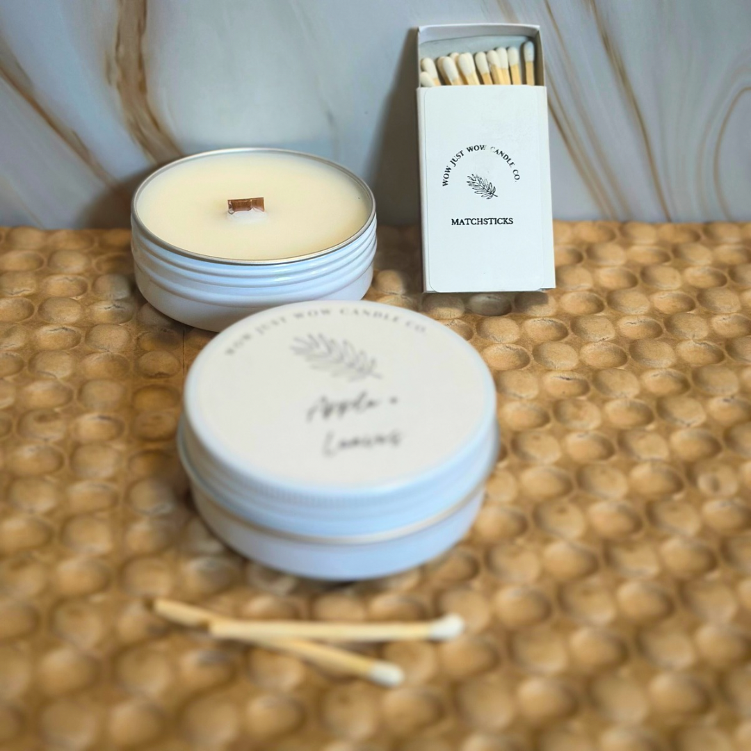 Unlit soy candles in stack with light-blue tins and wooden matchsticks