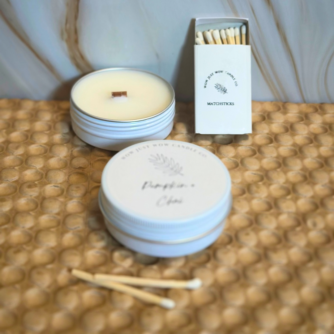 Unlit white Pumpkin + Chai soy candle tins with matchbox and wooden matches.
