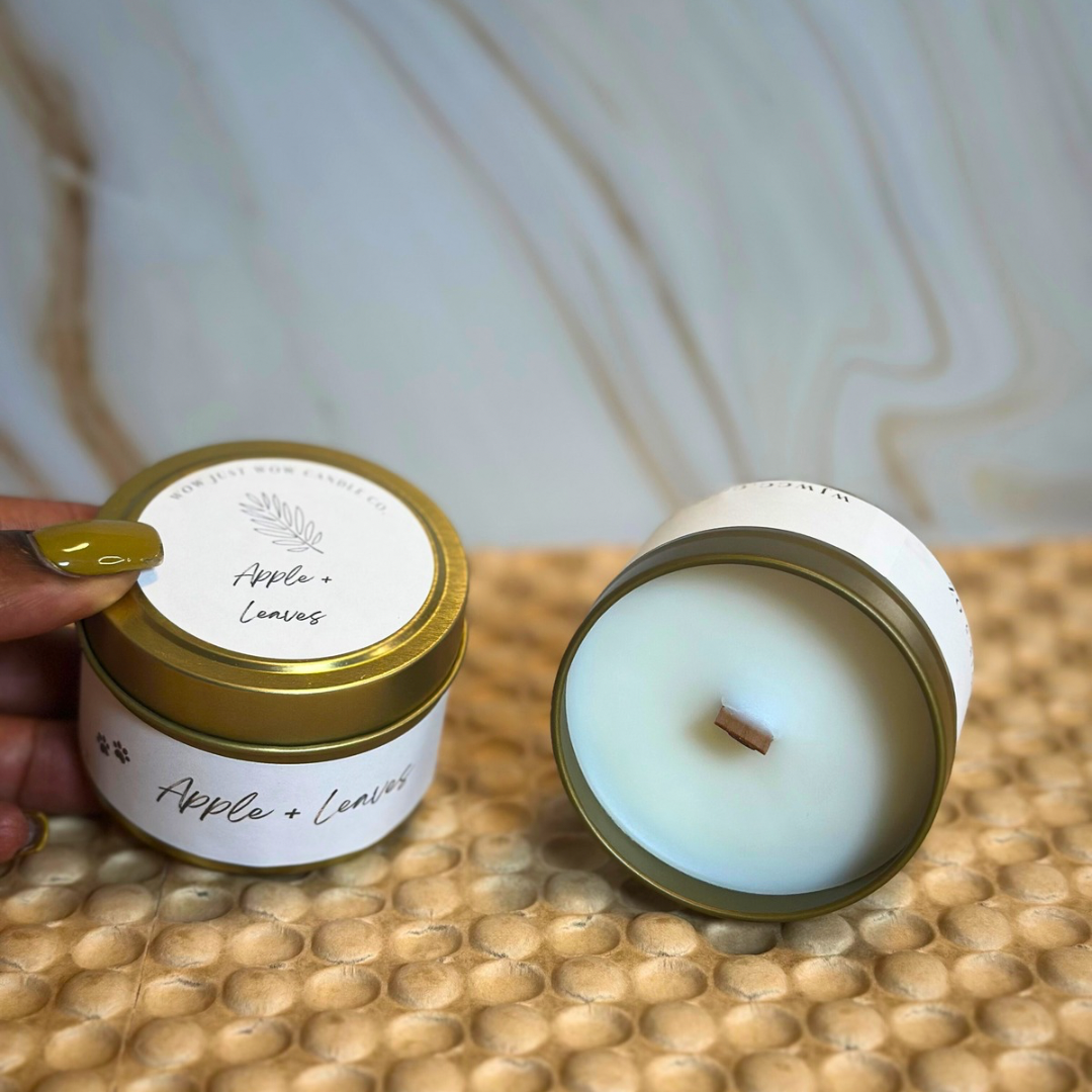 Hand opening soy candle lid to reveal unlit wick inside gold tin and light-blue jar