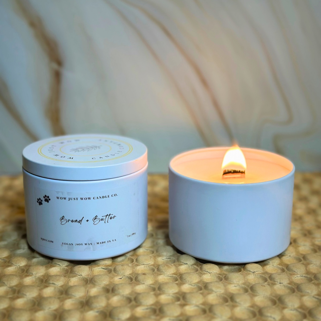 Soy candle in light blue container with lit wick, and silver-lidded candle jar