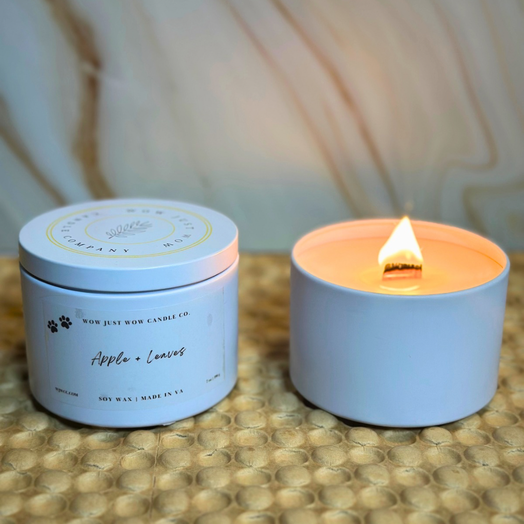 Lit soy candle in light-blue jar with Apple + Leaves label