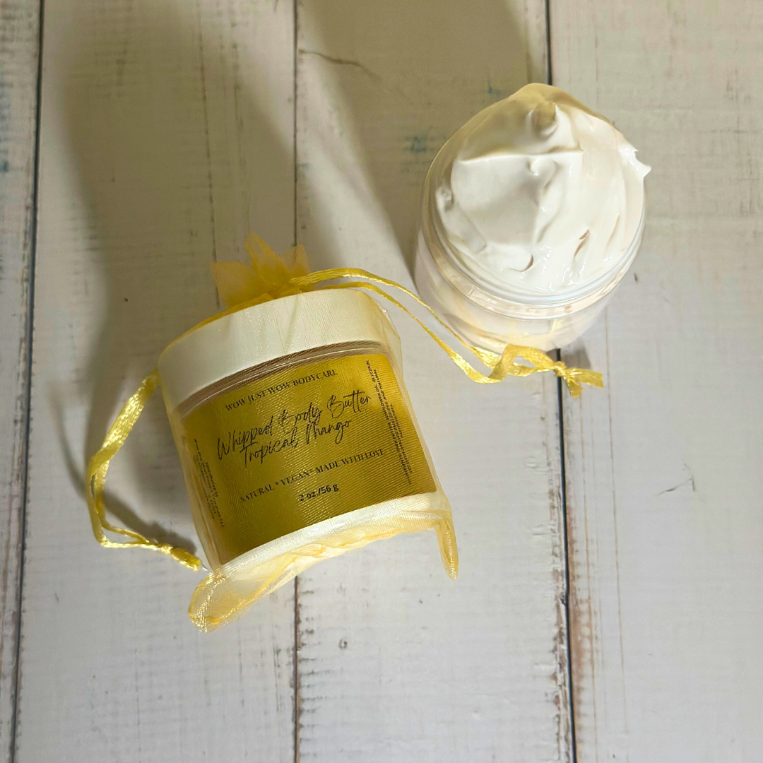 Two containers of whipped body butter on a wooden surface