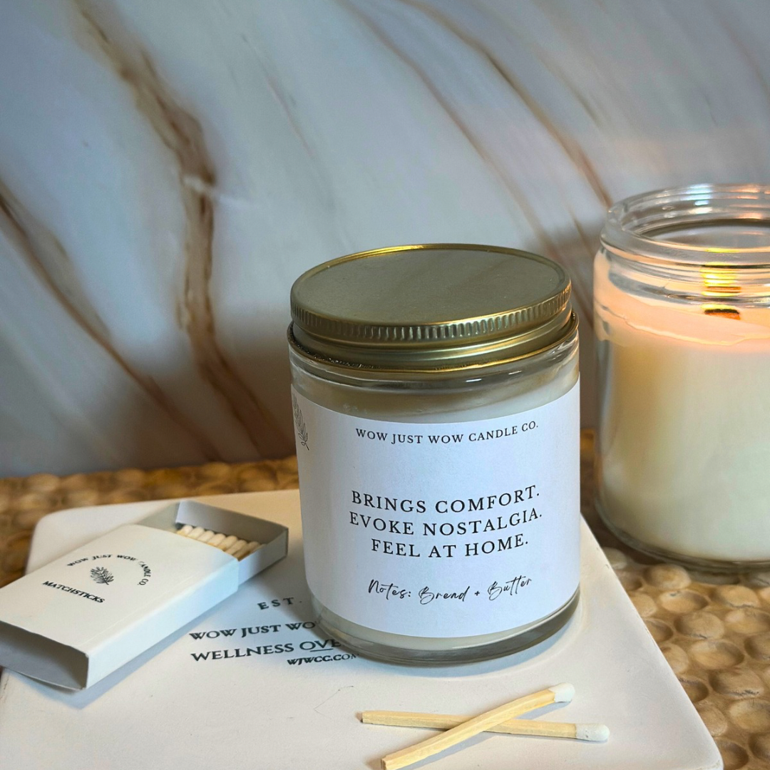 Jar candle with a label on a surface with matches and another candle in the background.