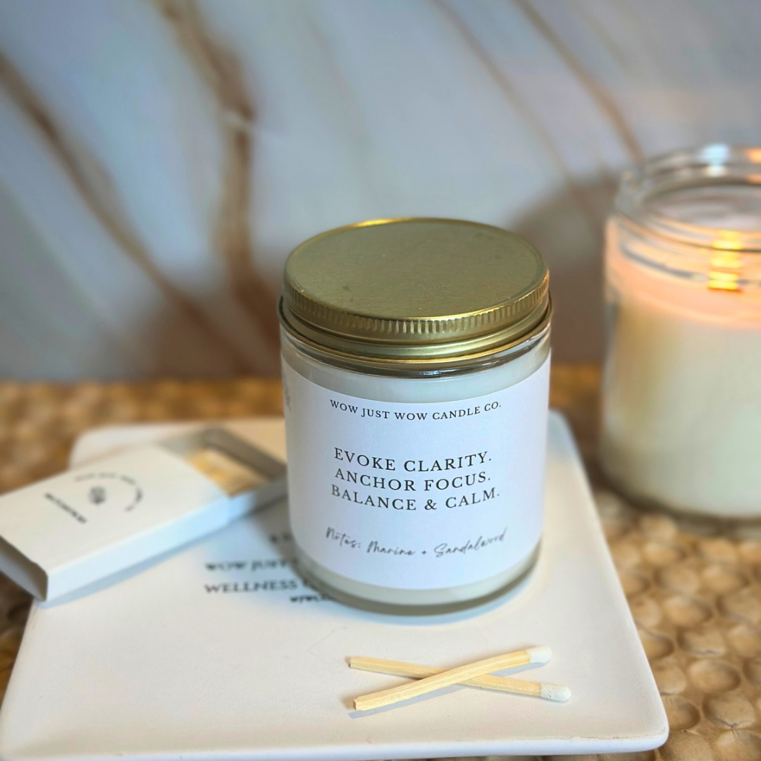 Candle jar with a gold lid on a white surface, with a blurred background