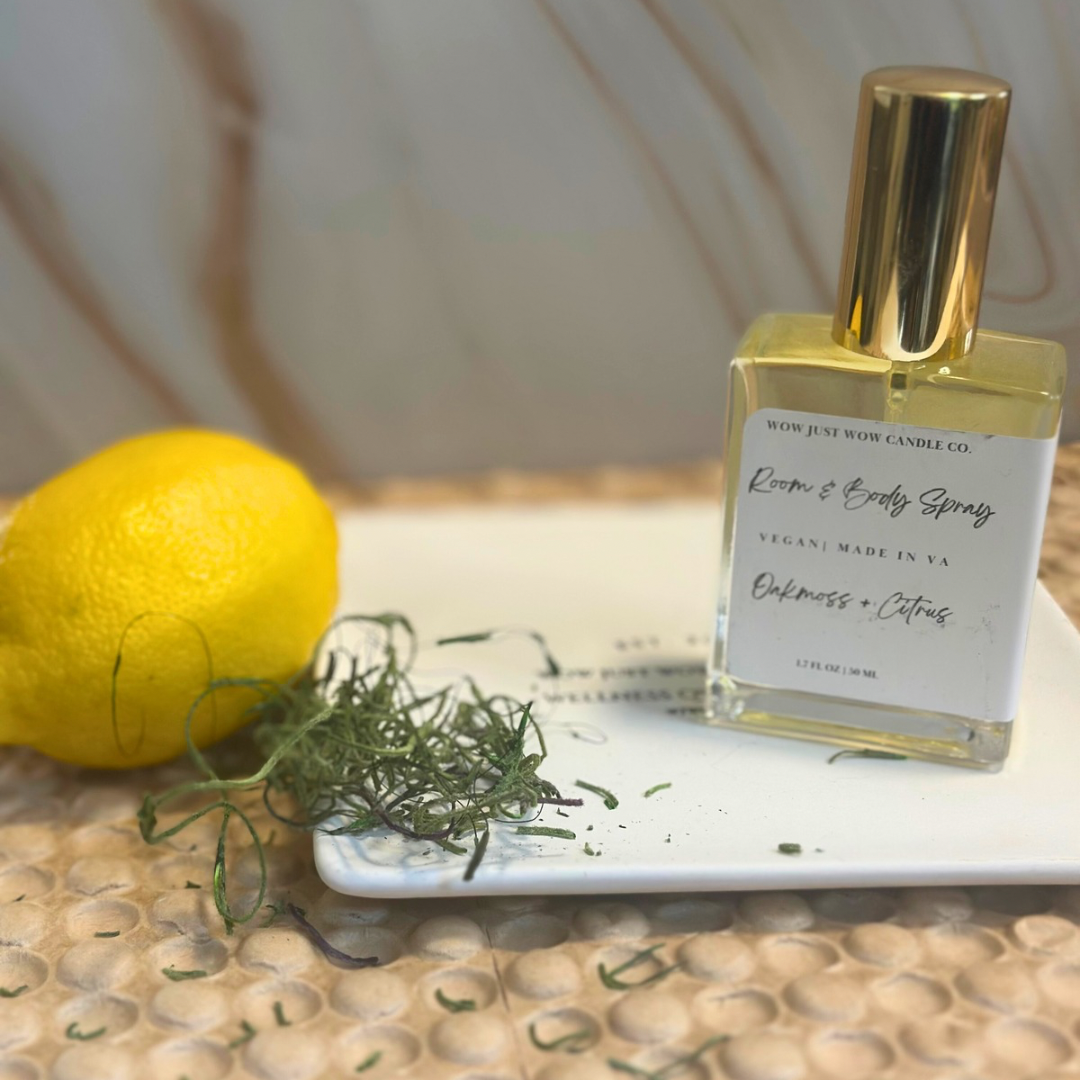 Room + Body Sprays: Multi-purpose fragrance mist in OAKMOSS + CITRUS for refreshing your space and skin. Body spray bottle with lemon and herbs on a textured surface