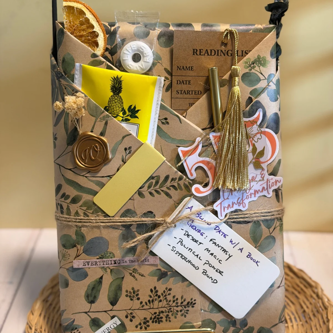 Decorative gift box with stationery items on a wooden surface