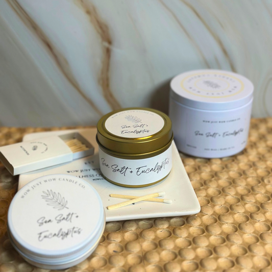 Three containers of 'Sea Salt + Eucalyptus' on a textured surface with a blurred background.